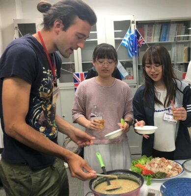 ドイツ料理を配膳する留学生